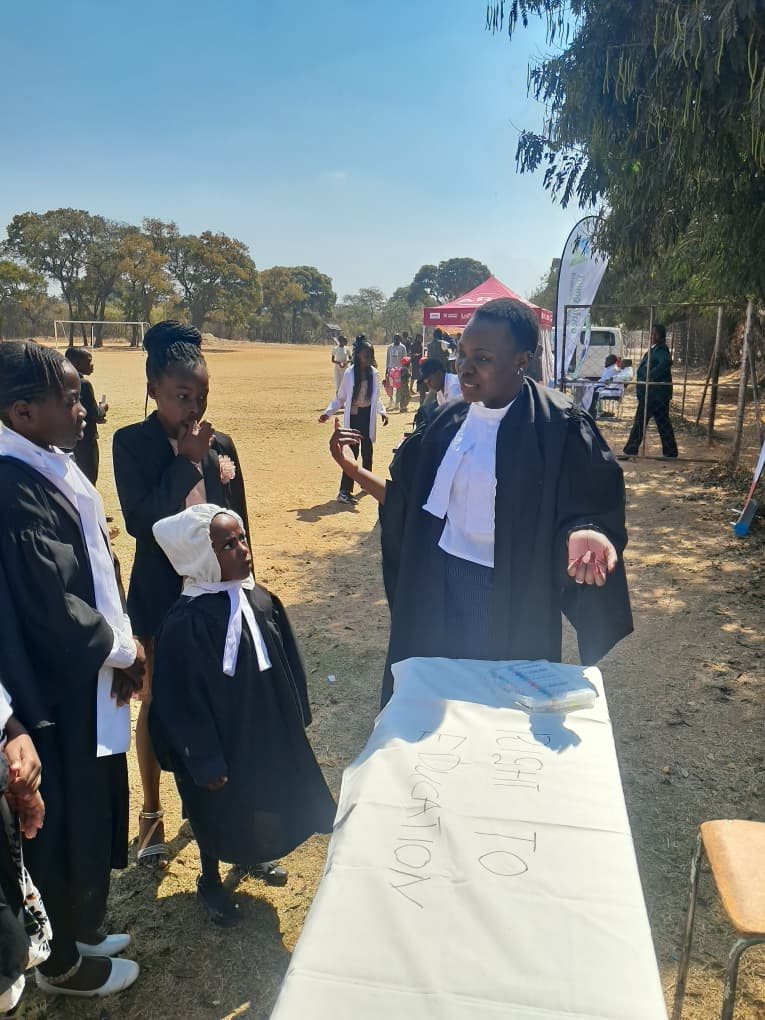 A facilitator explains the activity to a line of student participants in Junior Court robes