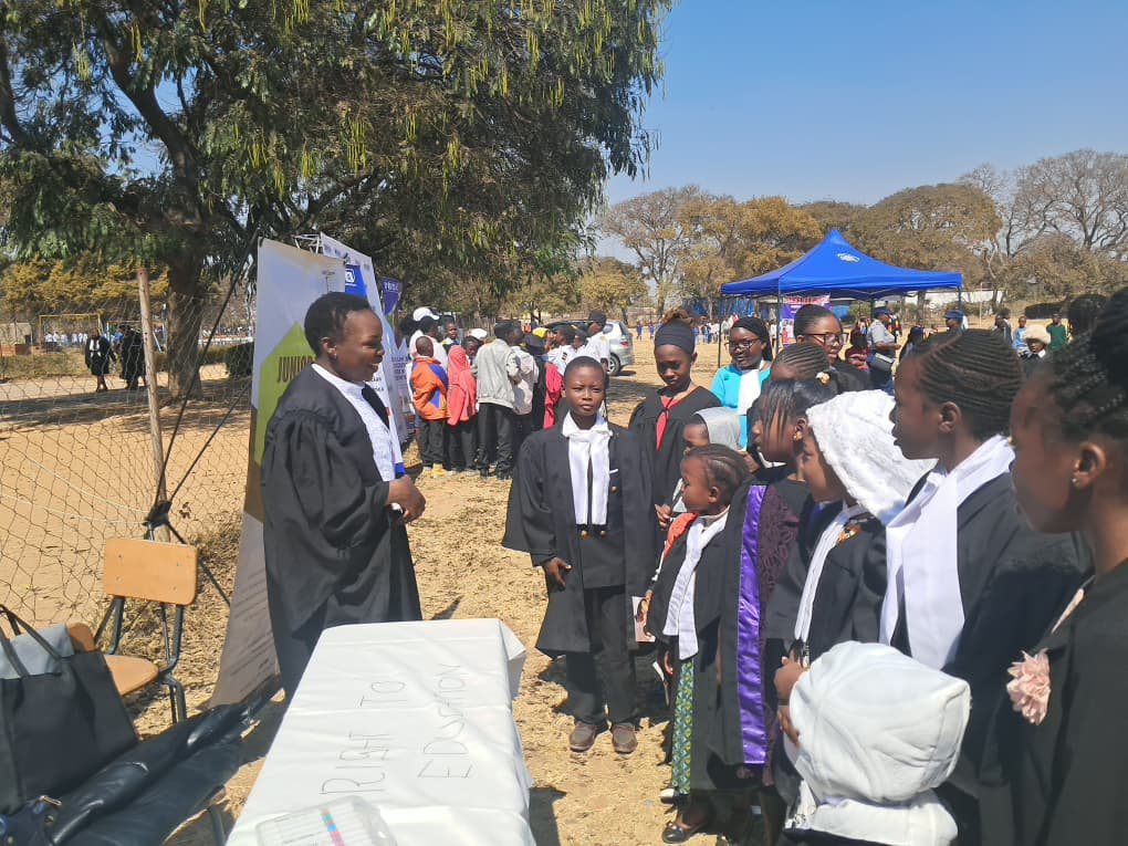 Close-up of a JCC facilitator addressing participants beside the Right to Education table