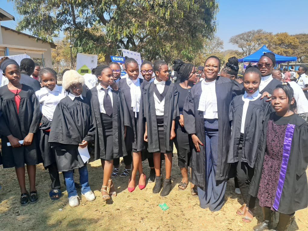 A large group of student participants in Junior Court robes posing with the JCC team